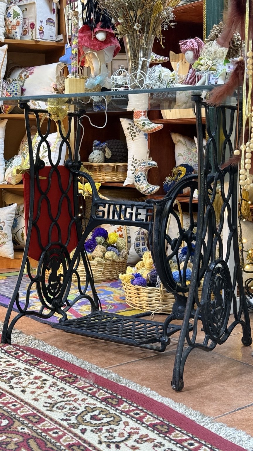 Rincón artesanal con máquina Singer y cojines bordados